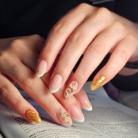 Des ongles sobres mais attirants. Entre blanc et doré, ils sont parfaits pour célébrer diverses occasions. Exemple réussi du nail art d'aujourd'hui avec des étoiles et serpents. Fait par Ongles et paillettes en loire Atlantique Ongles blancs et dorés. Un exemple de nail art avec des serpents sur les annulaires et une étoile sur les indexes.