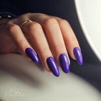 Ongles en forme d'amande, avec une pose de vernis semi-permanent violet. Ongles en forme d'amande, avec une pose de vernis semi-permanent violet.