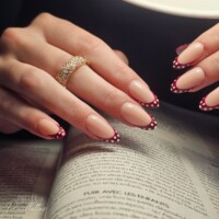Ongles en frome d'amande, avec une pose de vernis semi-permanent rose nude. L'extrémité des doigts est rouge bordeaux avec des points blancs. Ongles en frome d'amande, avec une pose de vernis semi-permanent rose nude. L'extrémité des doigts est rouge bordeaux avec des points blancs.